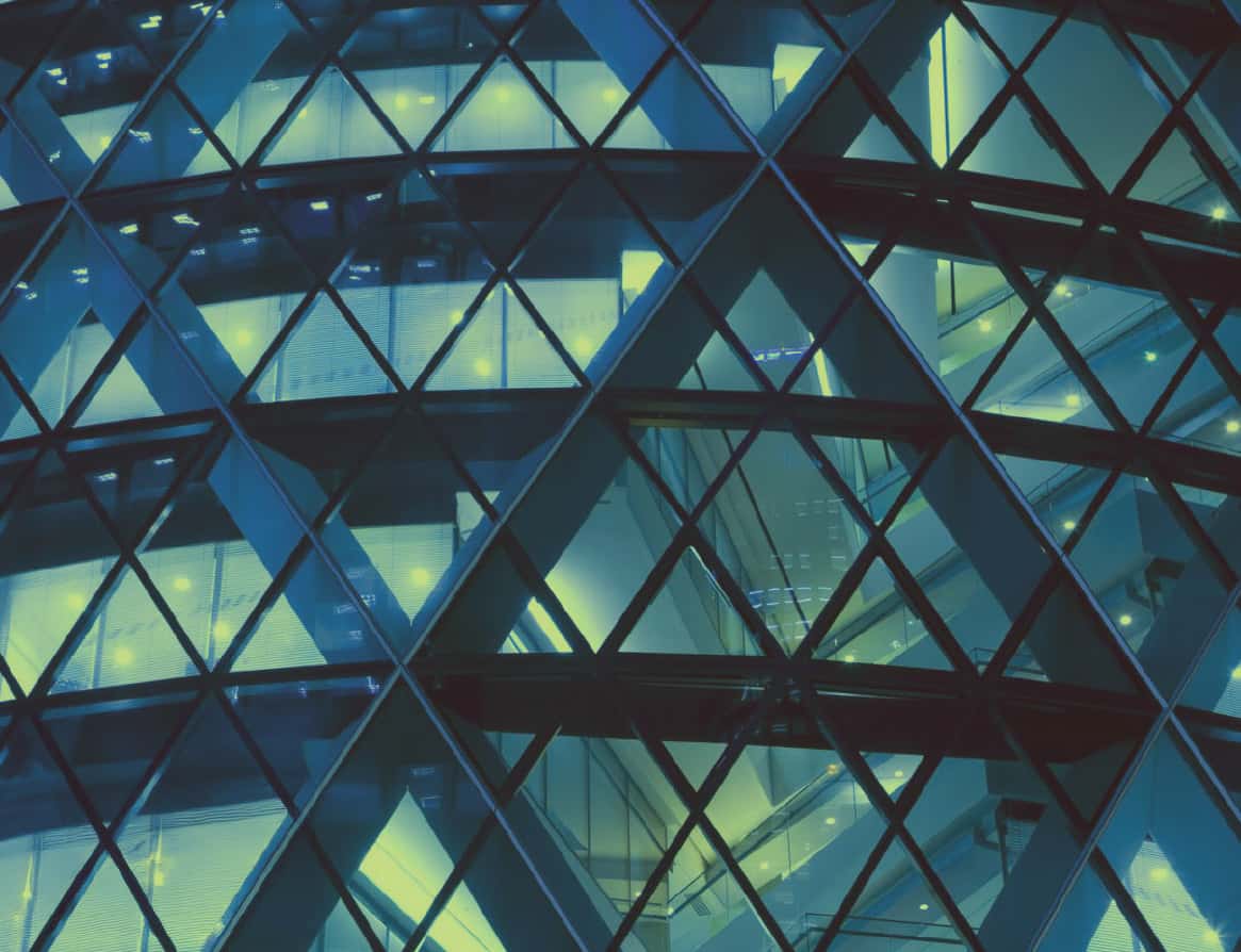 Abstract image of a modern glass building featuring a geometric pattern with blue and green lighting.